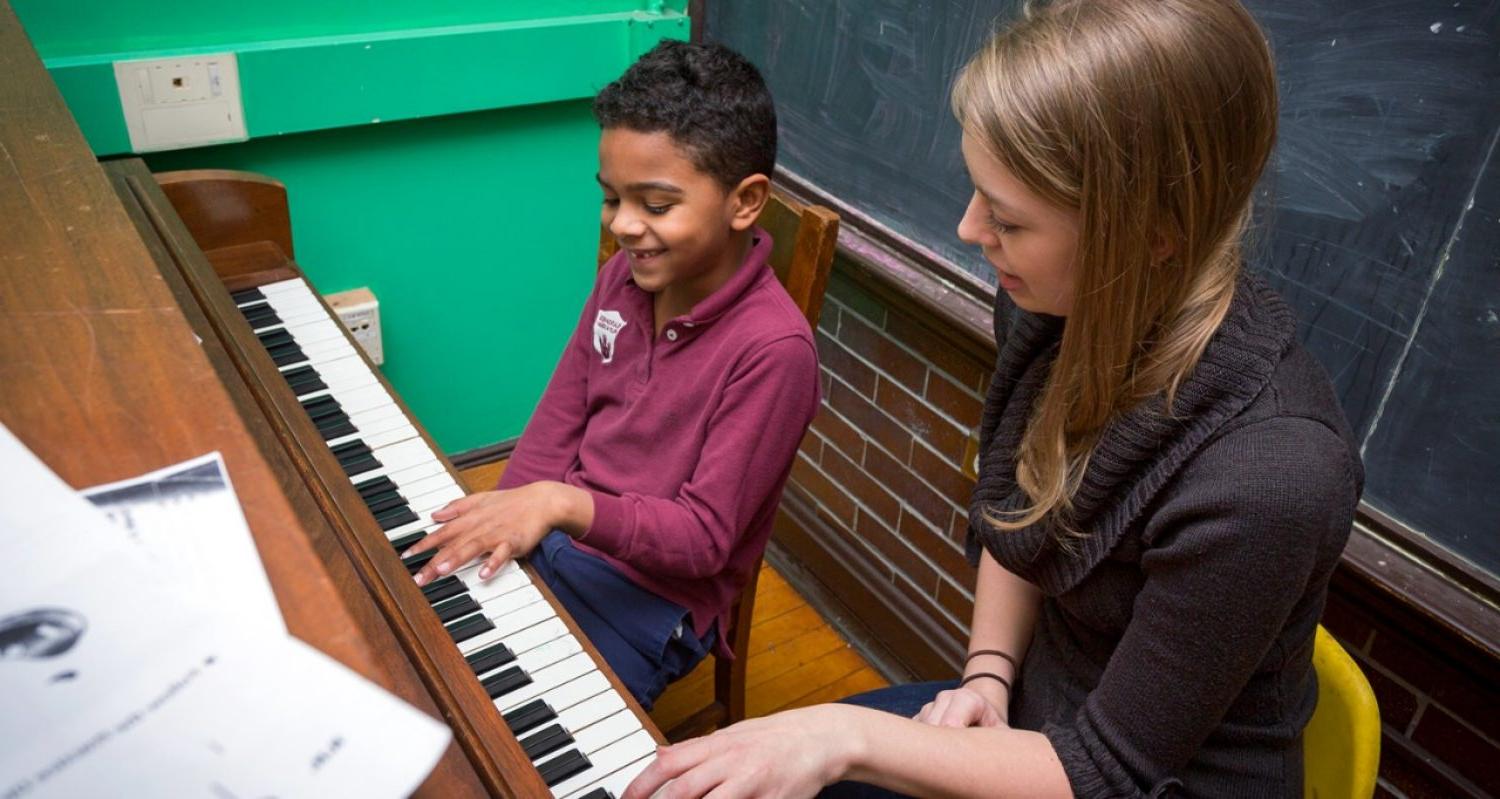 一位不列颠哥伦比亚省的音乐导师帮助一位年轻的学生学习钢琴.