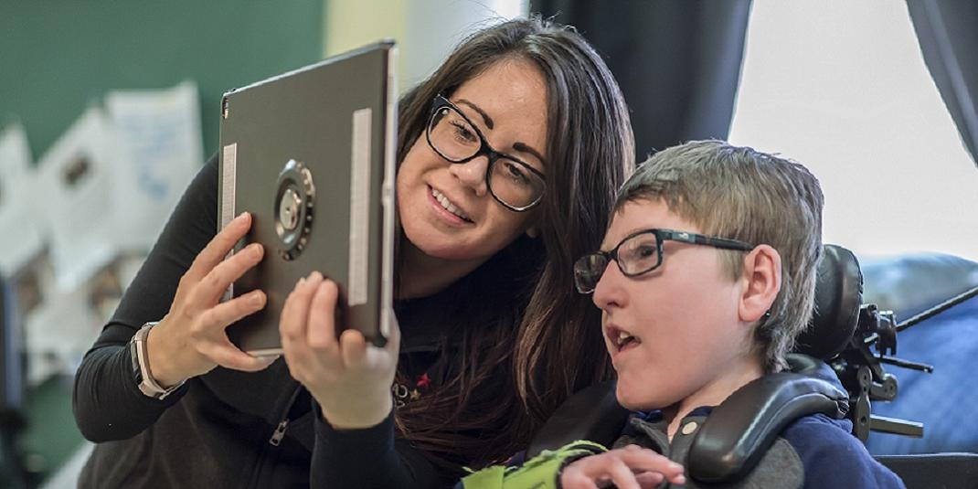 A student working with a teacher on an iPad